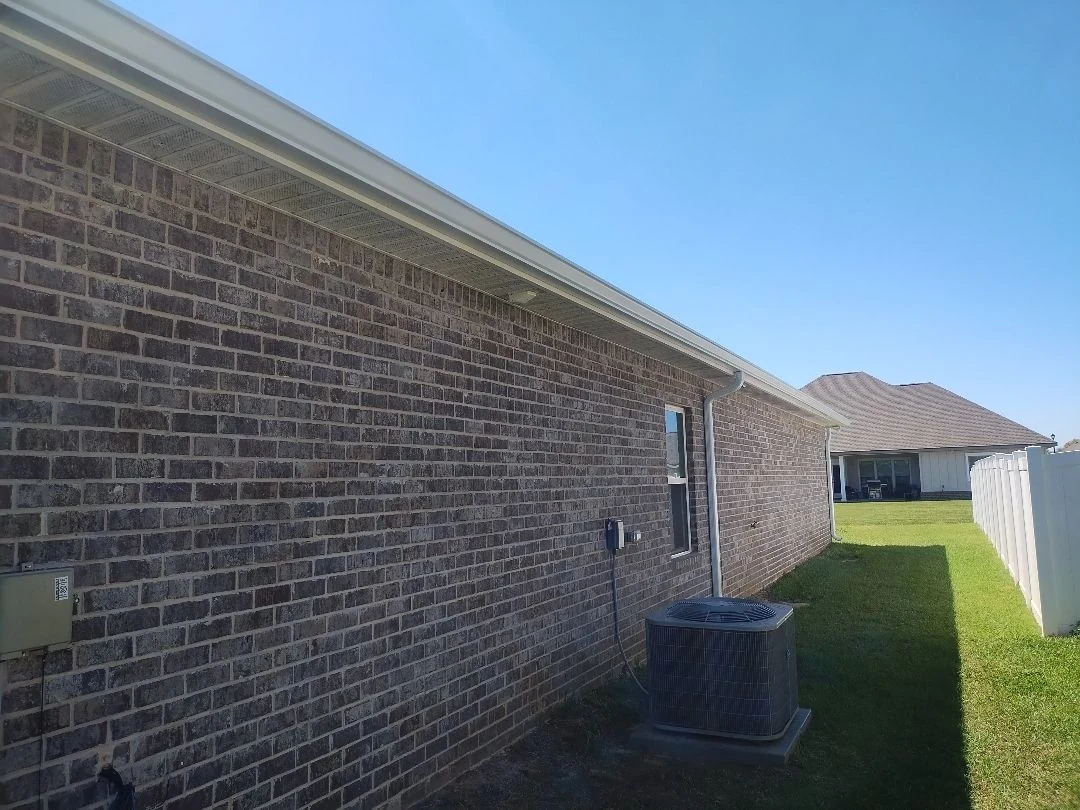 Brick home side with roofline and gutter detail.