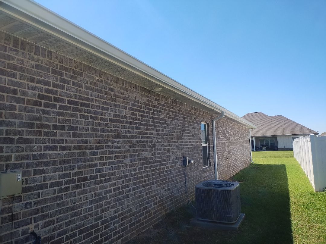 Brick home side with roofline and gutter detail.
