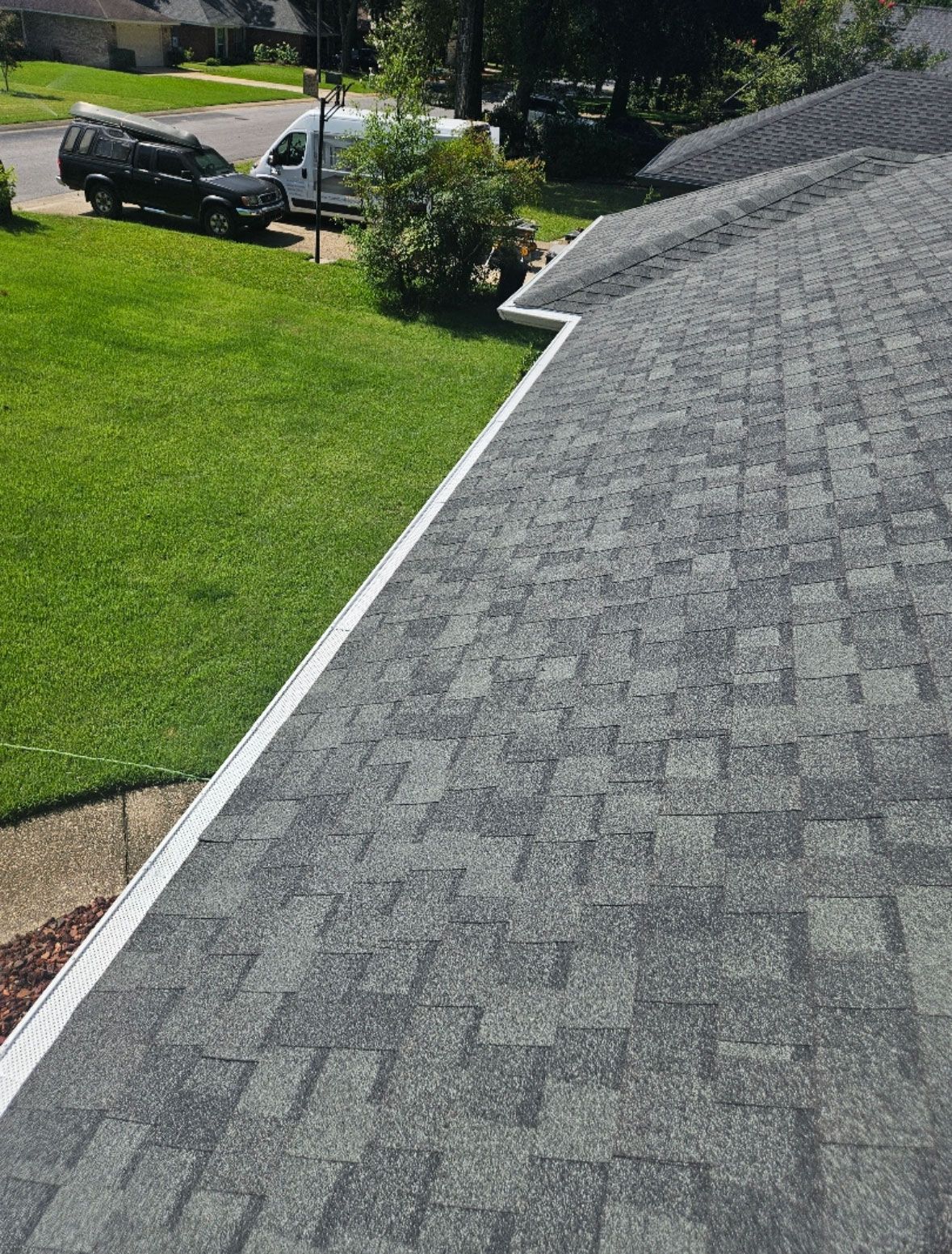 Portrait view of roofline with gutter installation.
