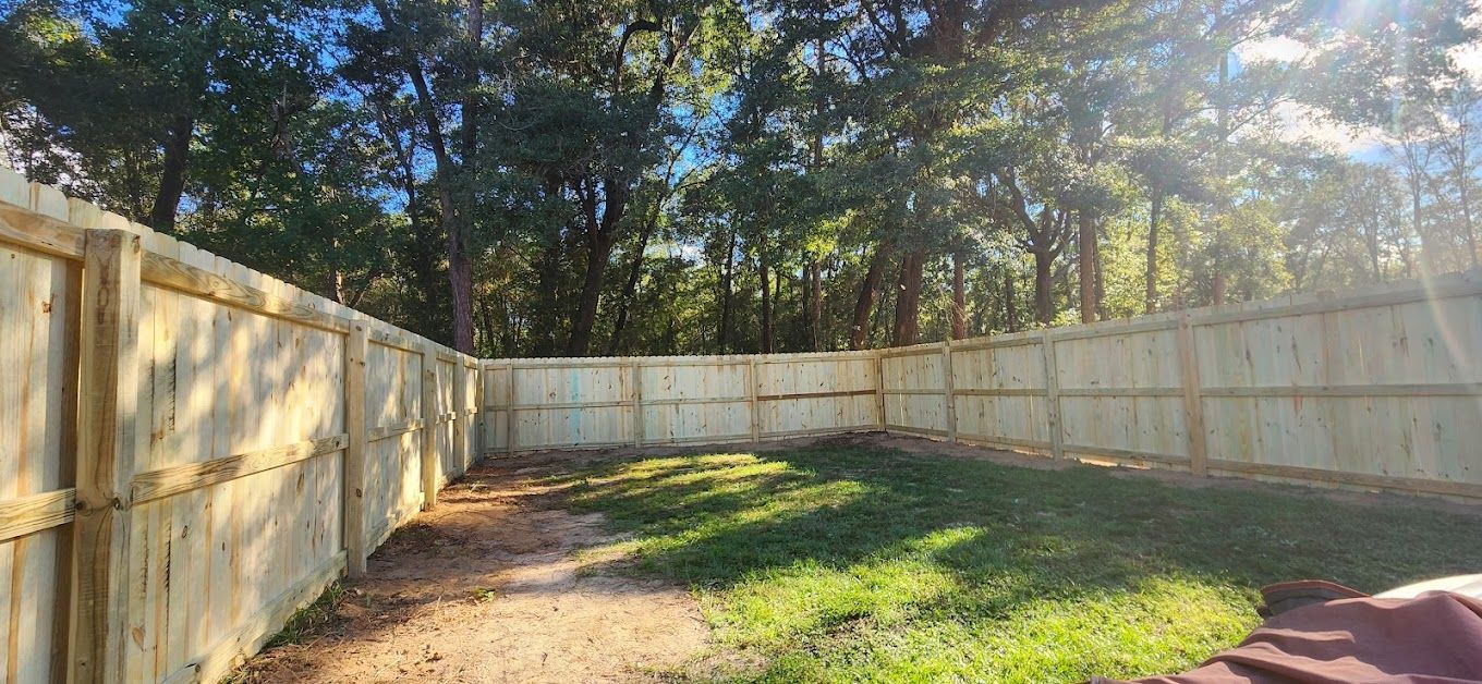 Long new wood privacy fence running beside a residential property.