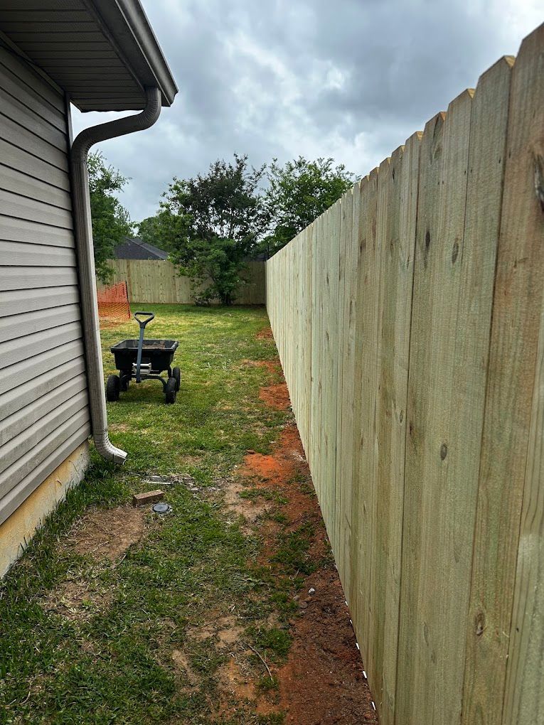 Wood privacy fence beside a house, vertical view.