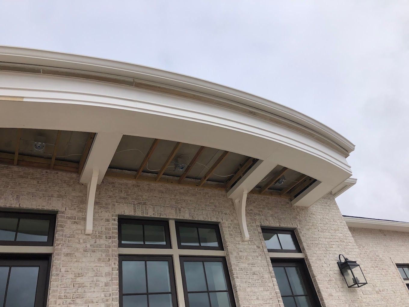Curved radius gutter installed at a brick entry arch.